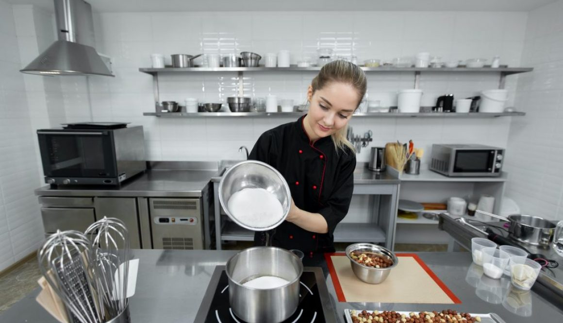 Pastry chef pours the sugar into a saucepan