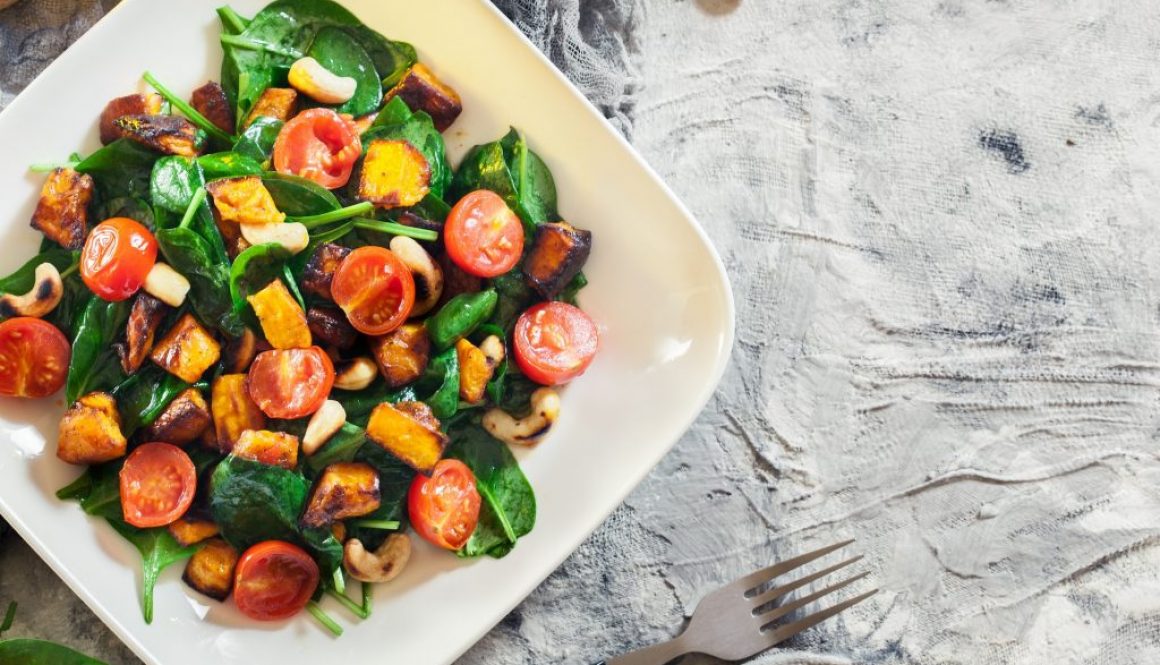 Gerösteter Kürbissalat mit Spinat, Tomaten und Nüssen