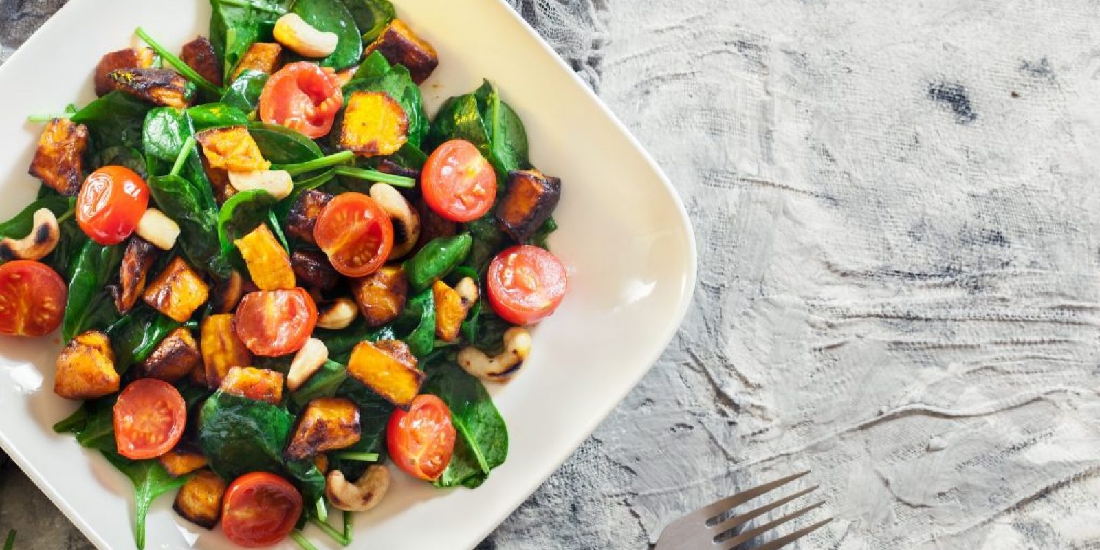 Gerösteter Kürbissalat mit Spinat, Tomaten und Nüssen