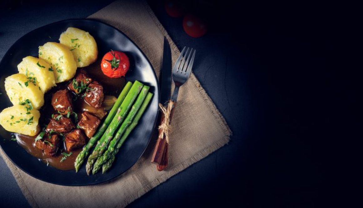 Knödel mit Rindergulasch und grünem Spargel