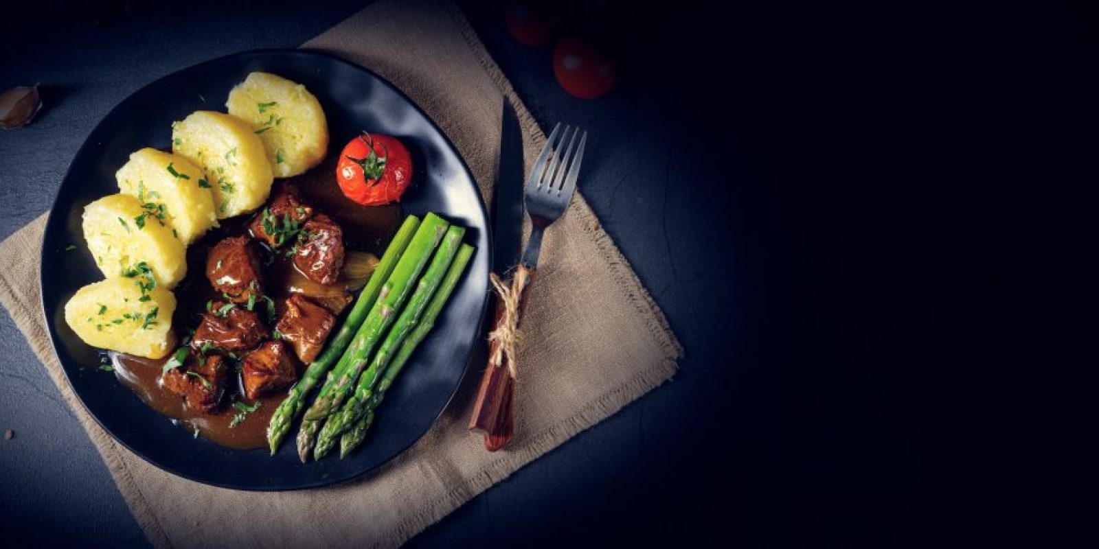 Knödel mit Rindergulasch und grünem Spargel