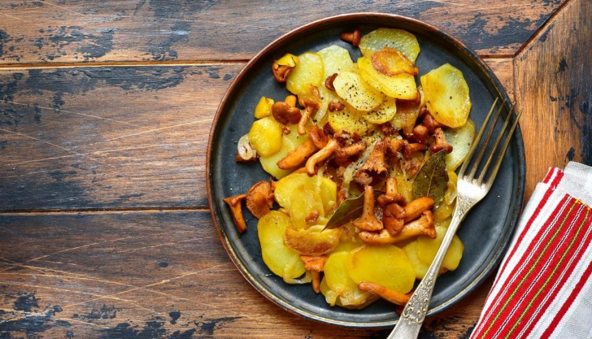 Mit Pfifferlingen und Zwiebeln gebratene Kartoffelscheiben