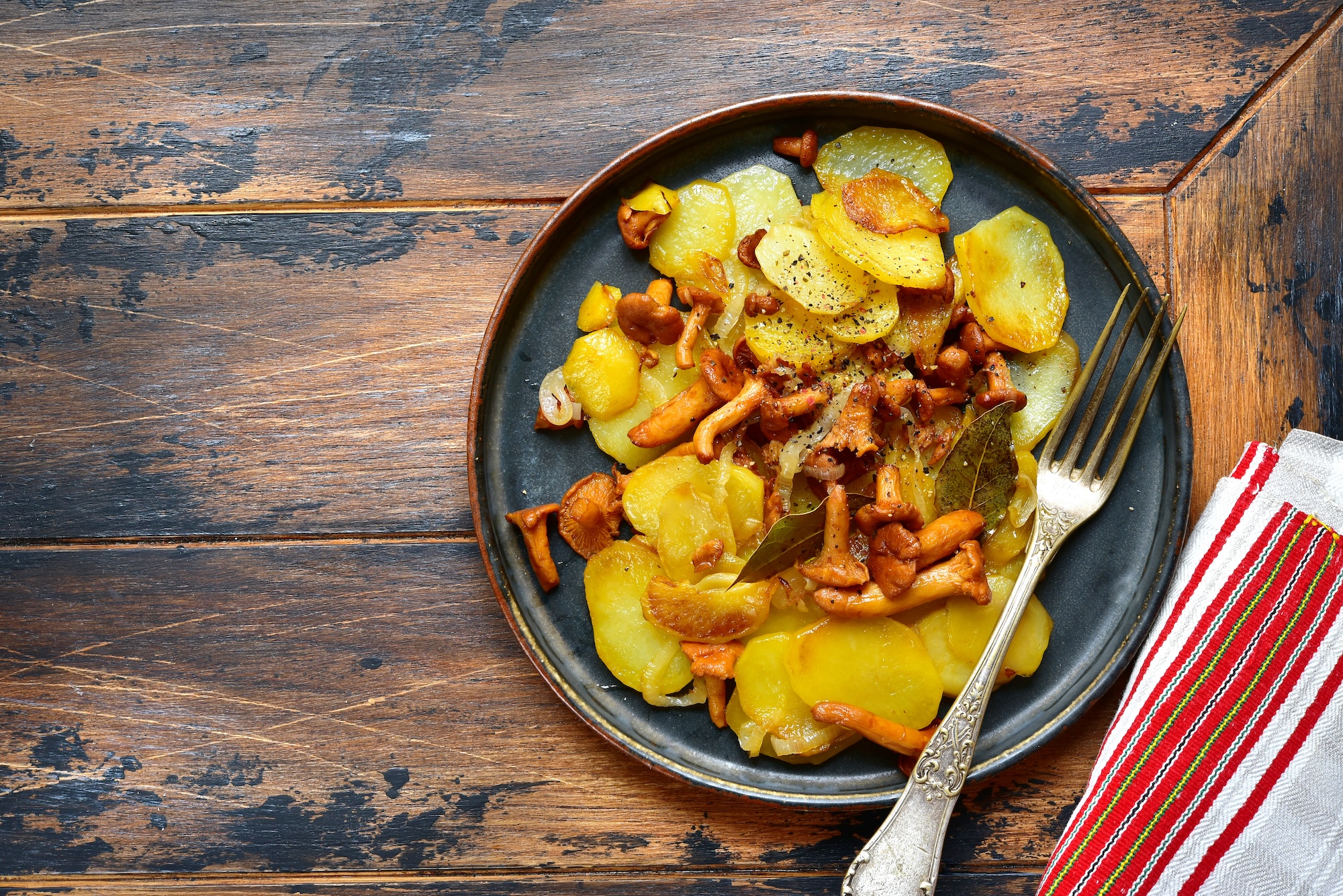 Mit Pfifferlingen und Zwiebeln gebratene Kartoffelscheiben Mit Pfifferlingen und Zwiebeln gebratene Kartoffelscheiben